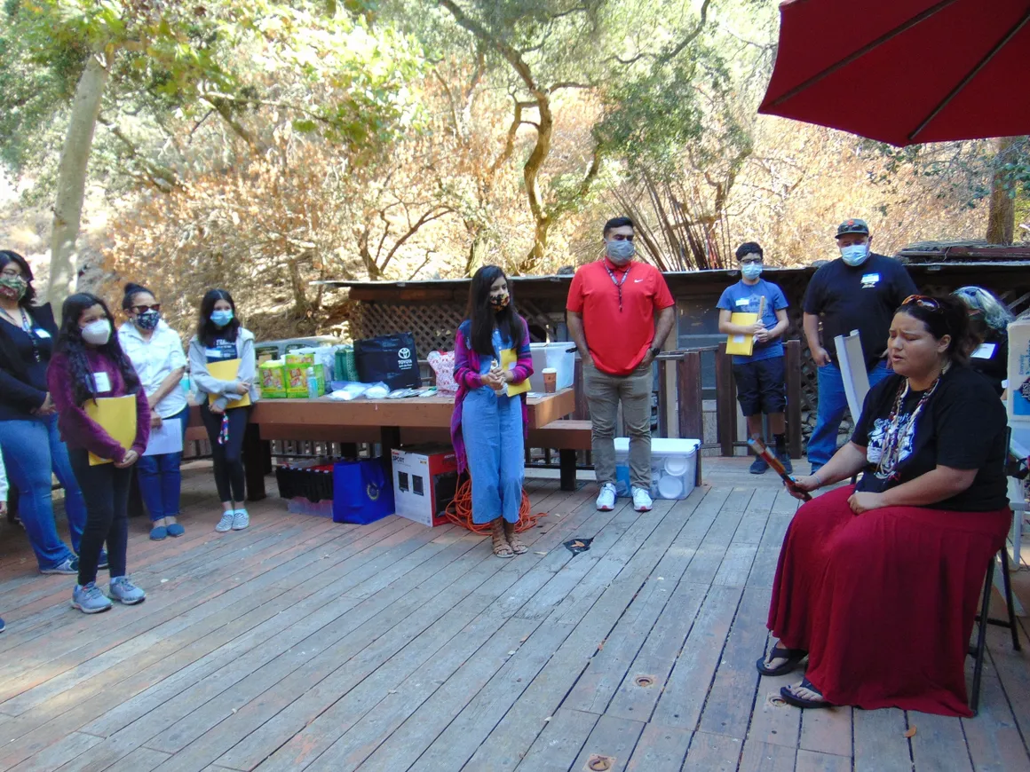 A group of people standing on top of a wooden deck.