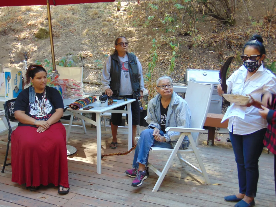 A group of people sitting on chairs outside.