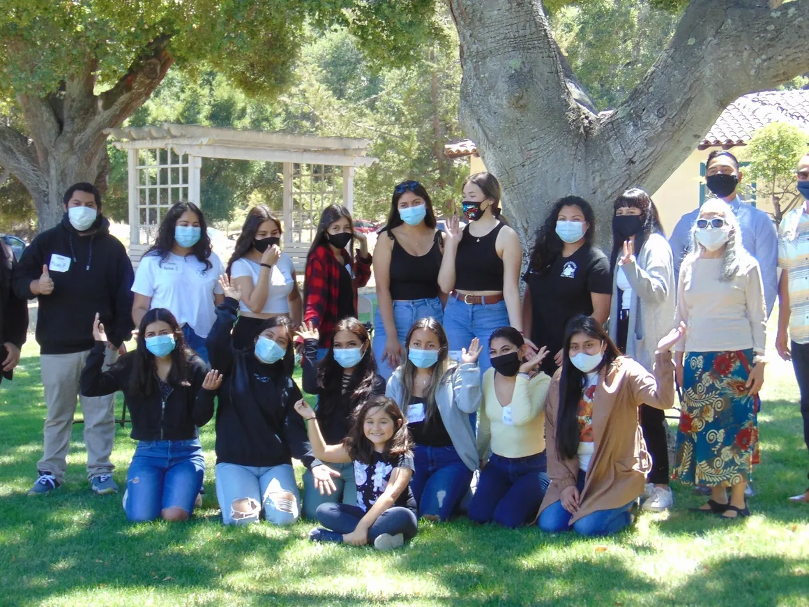 A group of people wearing masks posing for the camera.