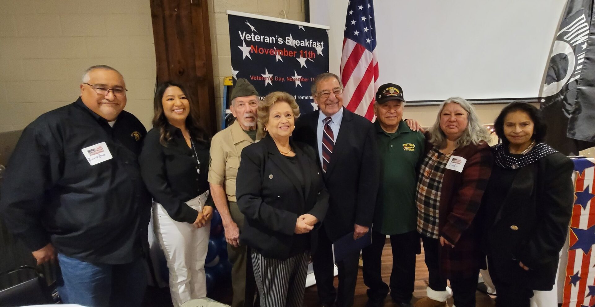 A group of people standing in front of an american flag.