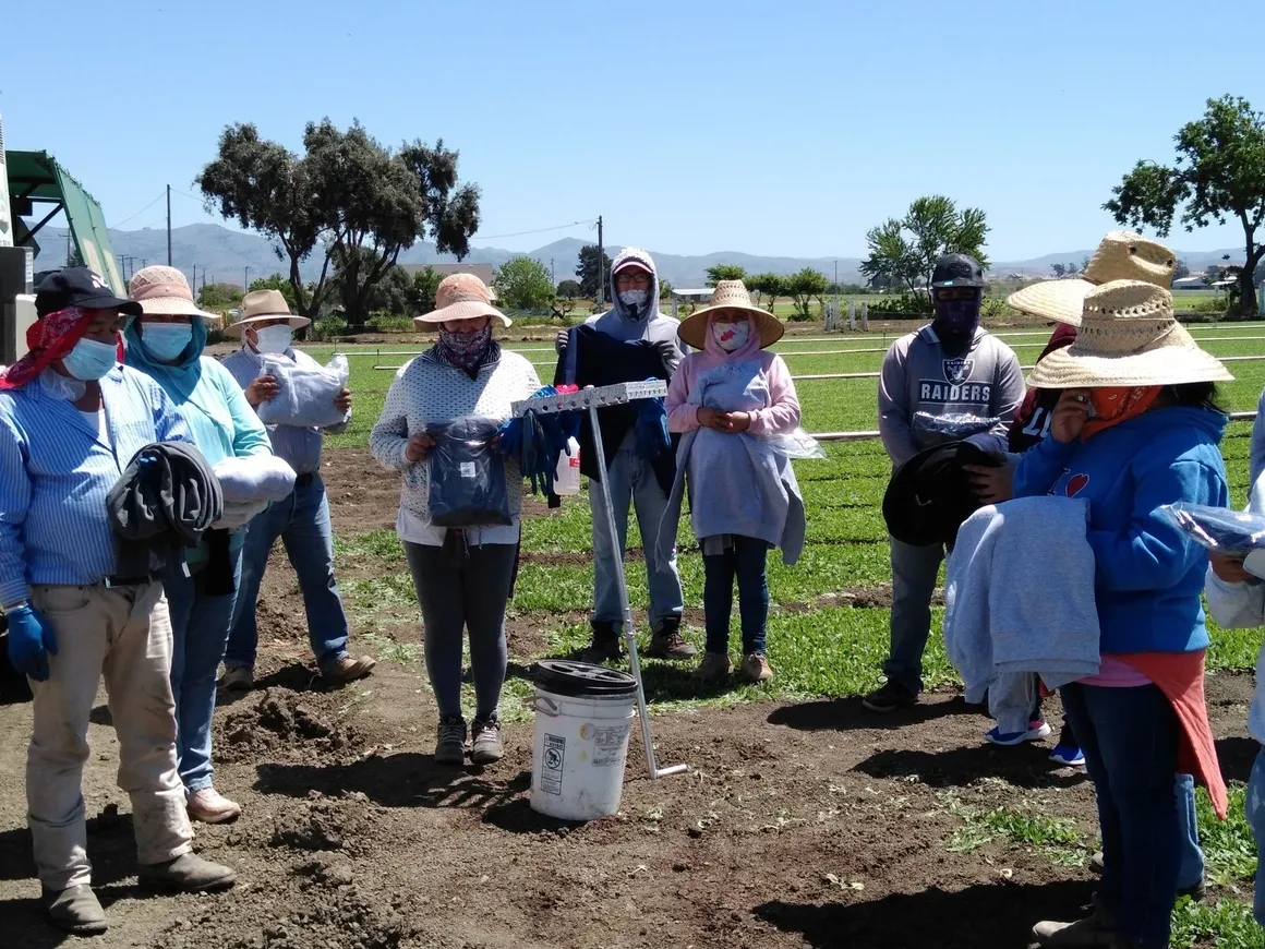 A group of people standing around in the dirt.