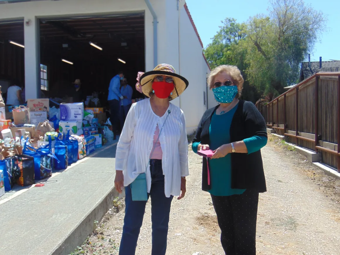 Two women wearing masks standing next to each other.