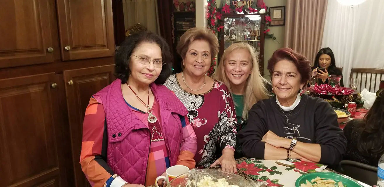 A group of women sitting at a table with cake.