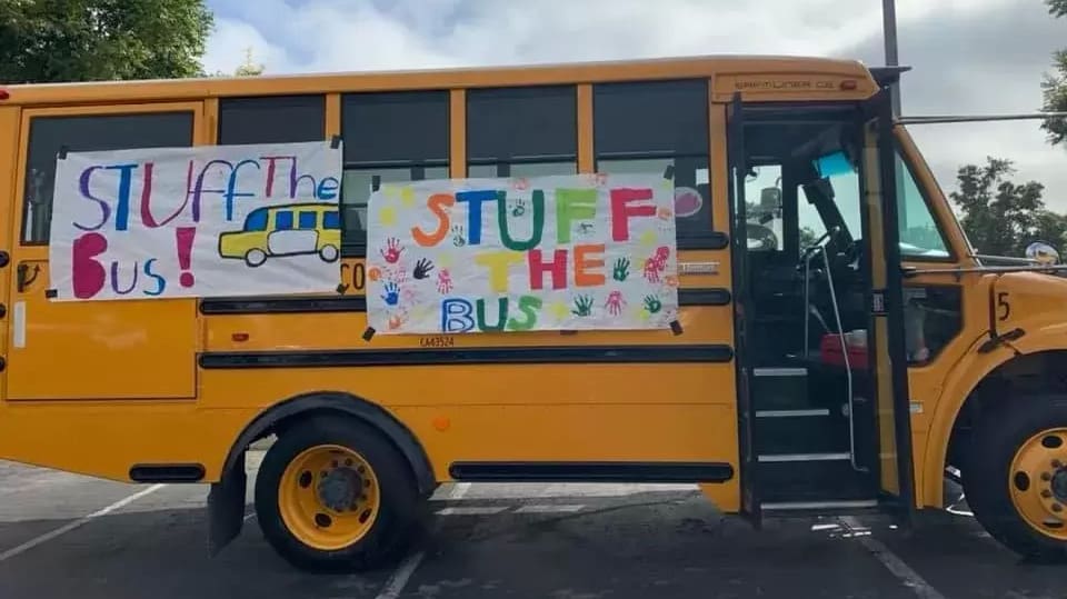 A yellow school bus with stuff the bus written on it.