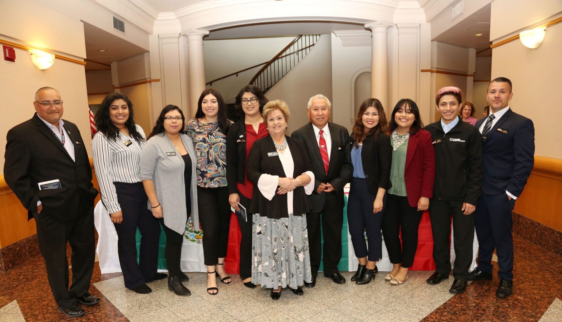 A group of people standing in front of a wall.