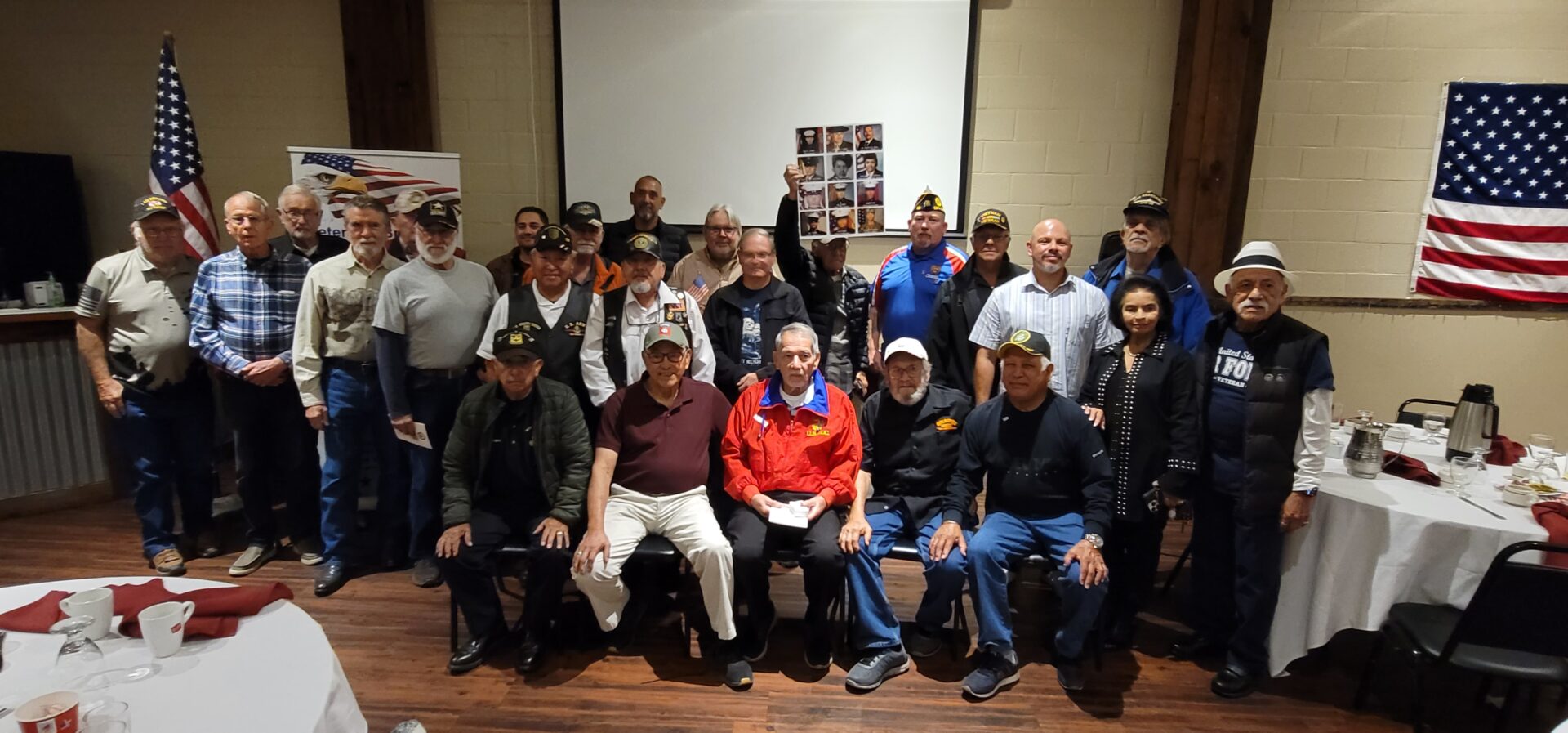 A group of men sitting in front of a projector screen.