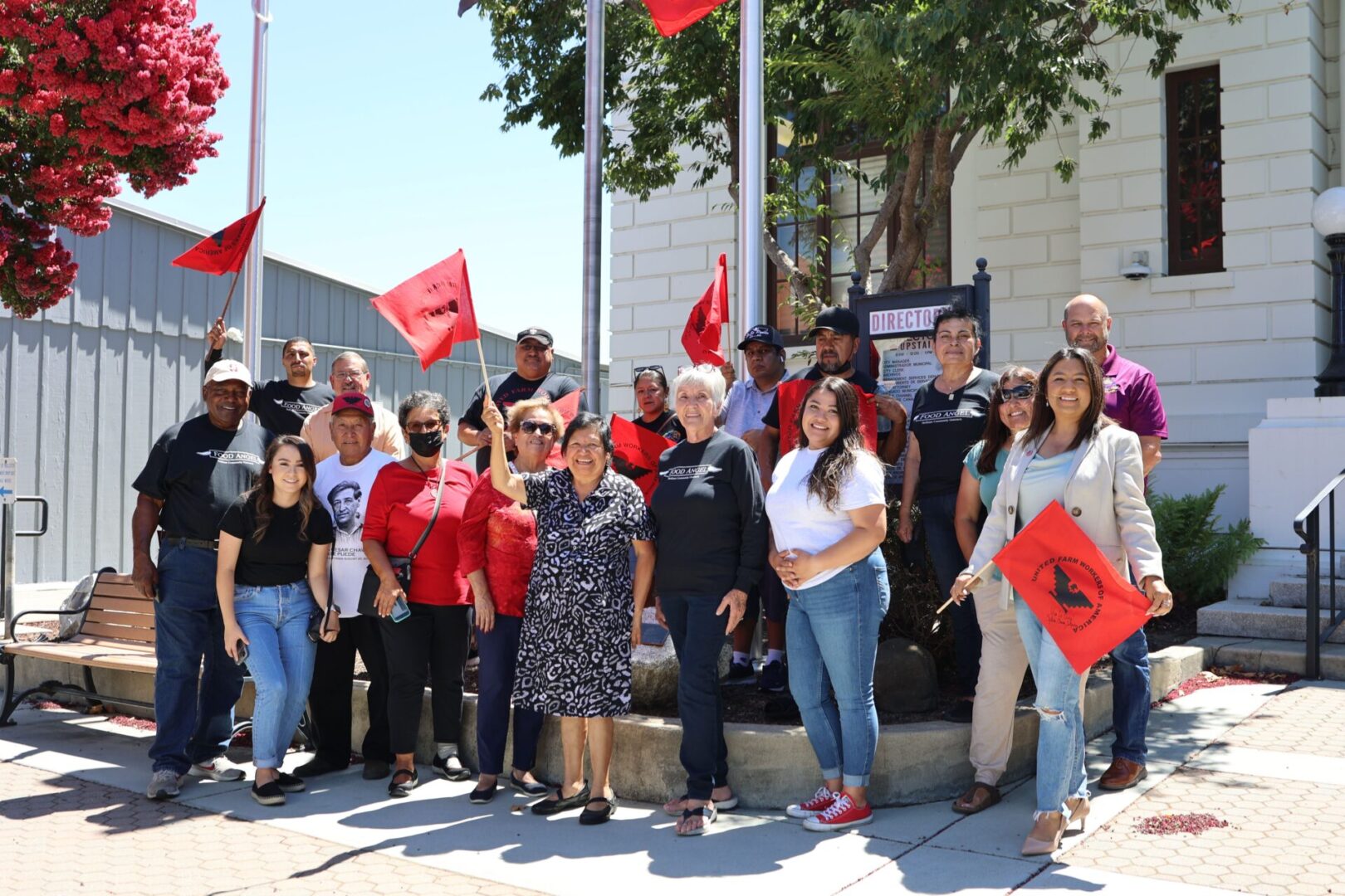 A group of people standing in front of some flags.